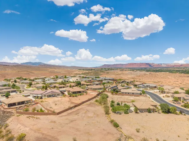 Expansive residential development featuring single-story homes with tile roofs, surrounded by natural desert landscaping