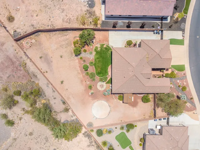 Expansive property featuring a tiled roof residence, a distinct green turf area, and desert landscaping