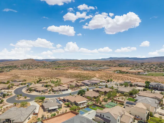 Aerial overview of a residential development featuring single-family homes with pitched roofs, desert landscaping, and private courtyards