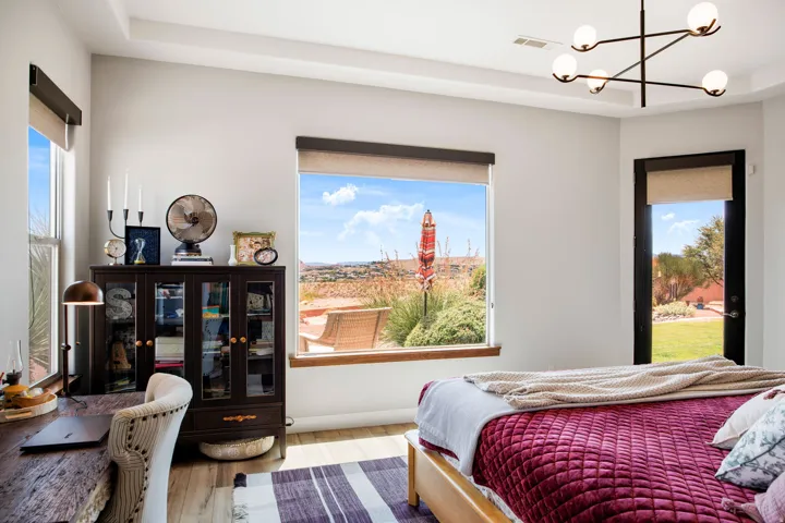 Room featuring light wood-finish flooring, a tray ceiling, and a modern chandelier