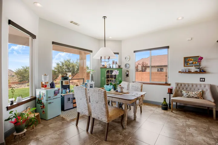 Bright dining area featuring tile flooring, a contemporary pendant light fixture, recessed lighting, and multiple large windows