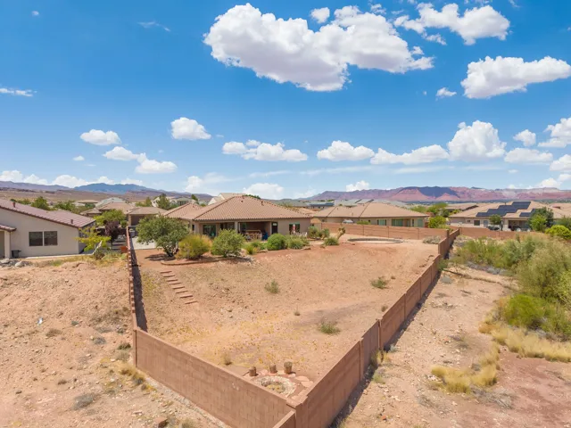 Expansive property featuring a large backyard, concrete block perimeter fencing, and mature trees