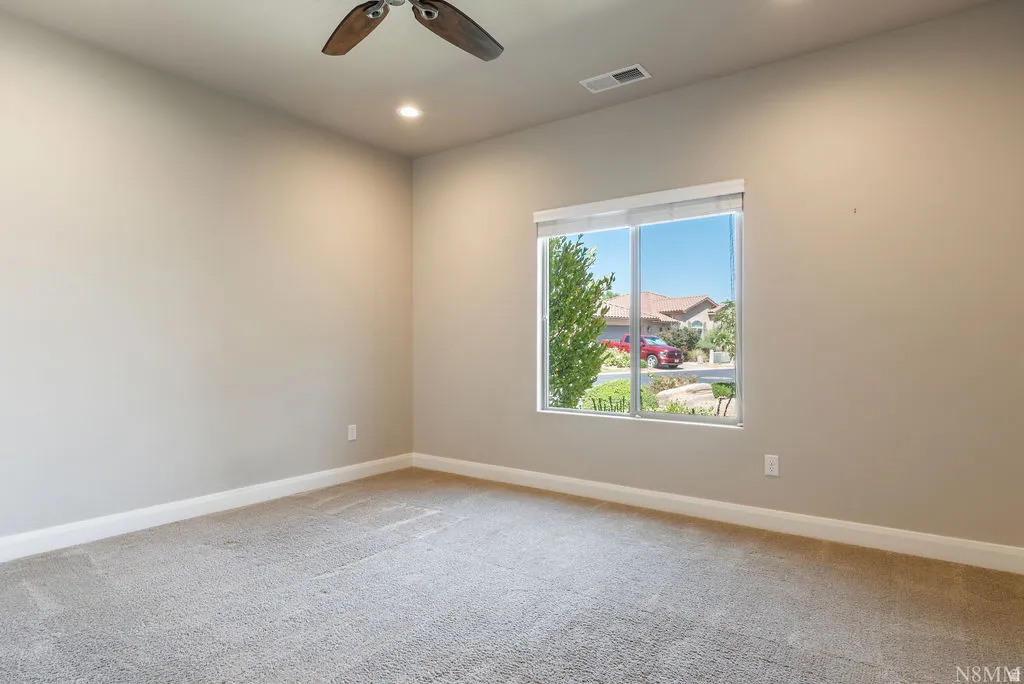 Recessed lighting, ceiling fan, neutral wall color, window with exterior scenery, and carpeted flooring