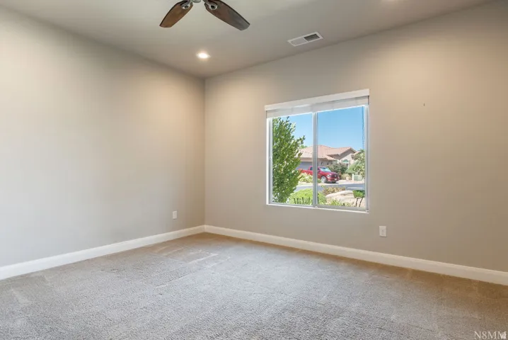 Recessed lighting, ceiling fan, neutral wall color, window with exterior scenery, and carpeted flooring