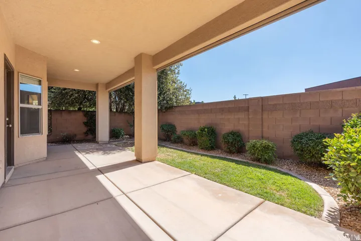 Covered patio with recessed lighting, concrete flooring, and a manicured lawn