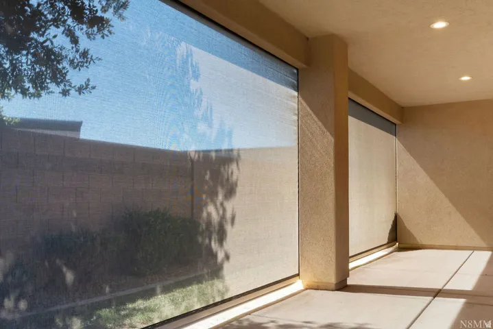 Covered patio with recessed lighting, integrated roller shades, and concrete flooring