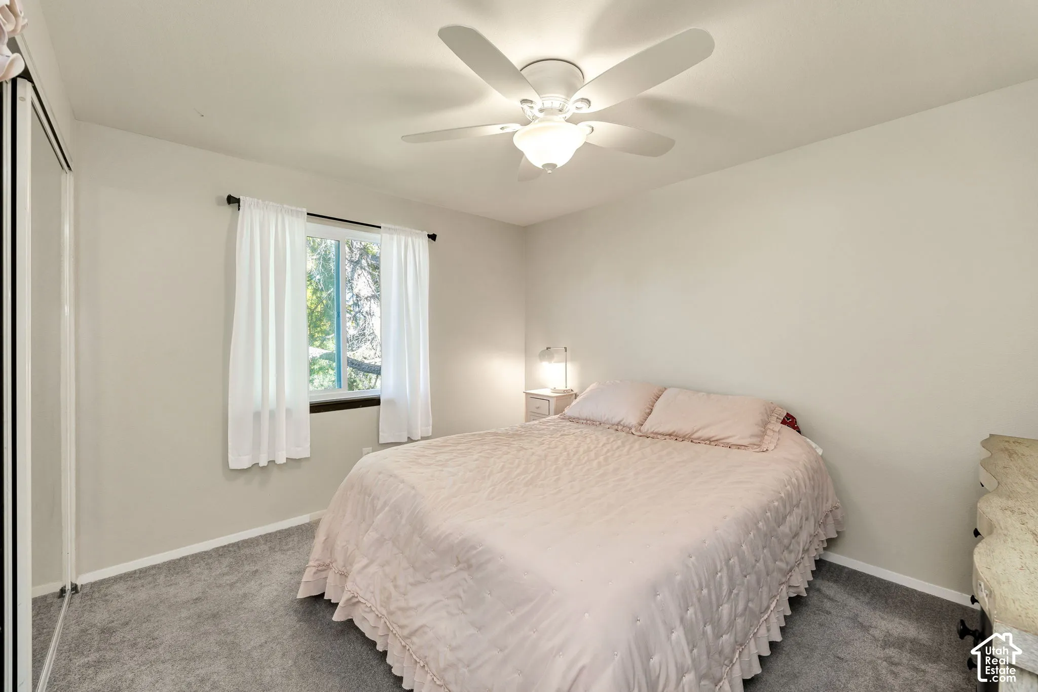 Recessed window with dark trim, ceiling fan with integrated lighting, and wall-to-wall carpeting