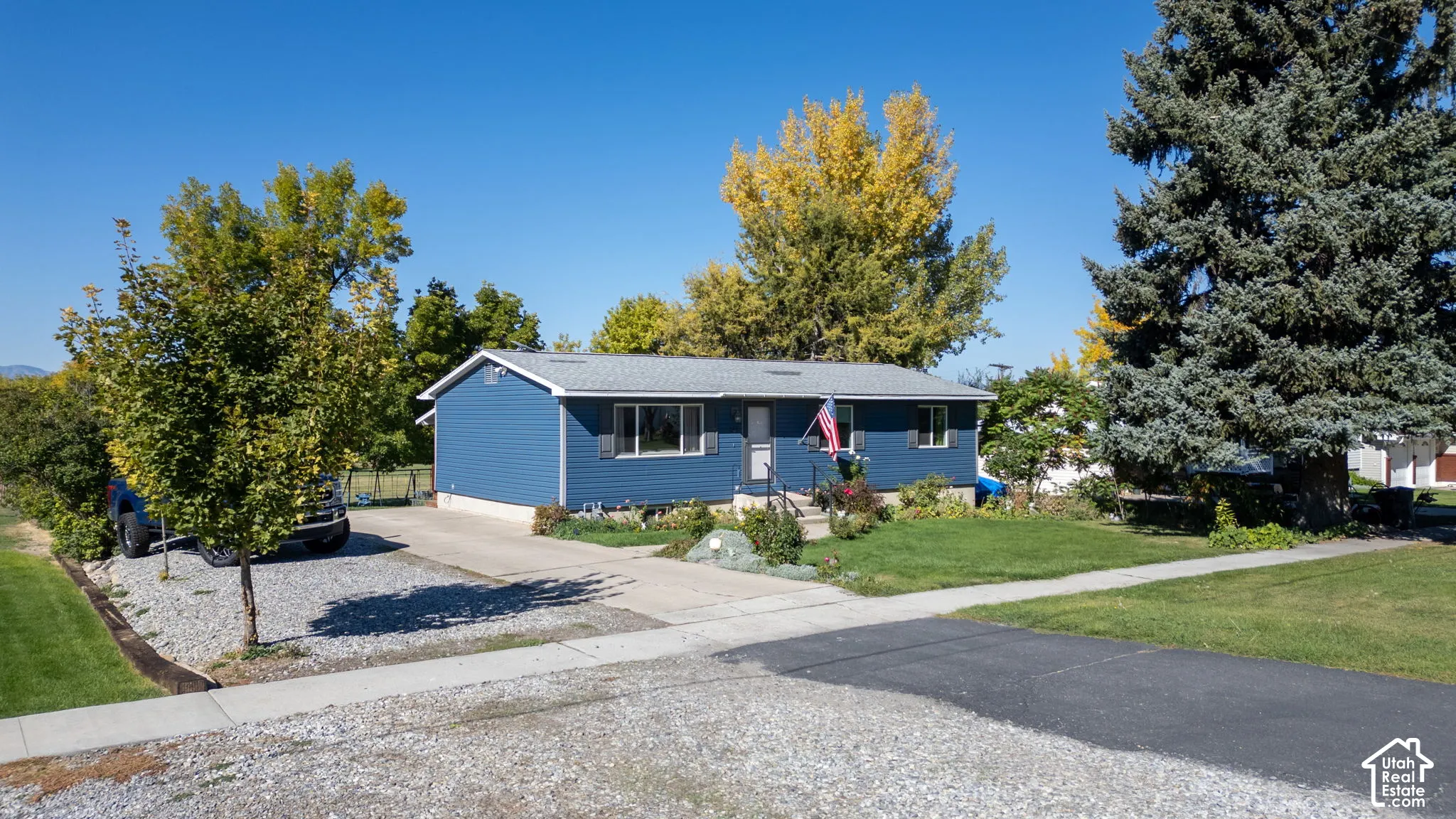 Single-story residence featuring blue siding and a gray shingle roof