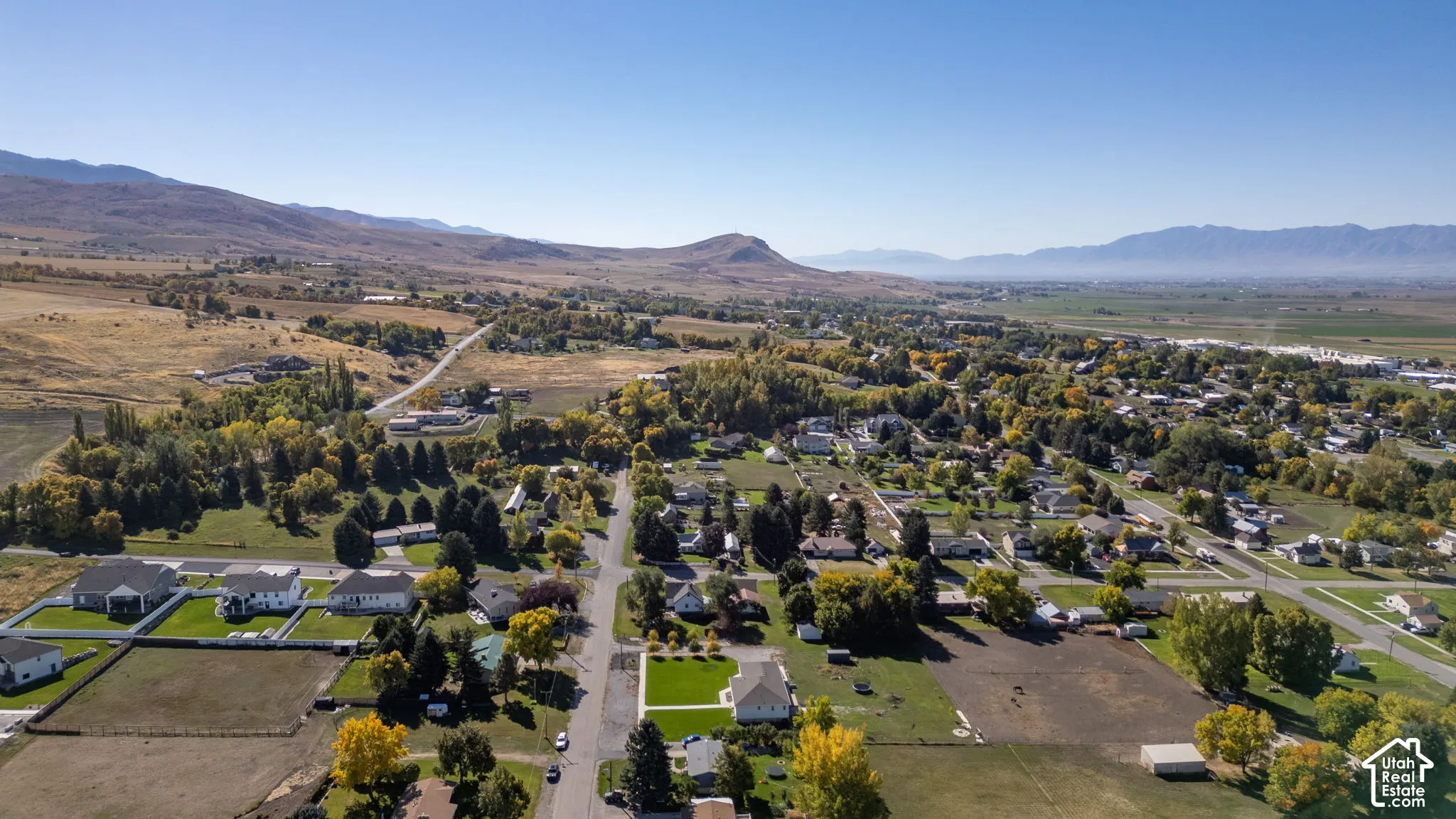 Expansive mountain backdrop with a developed community featuring residential homes and mature trees