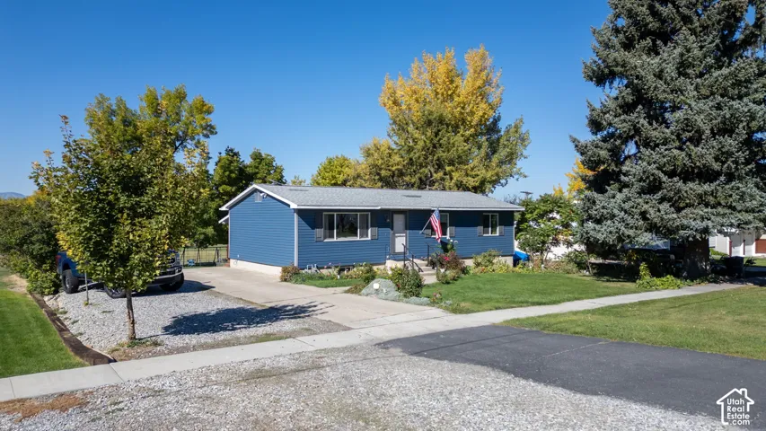 Single-story residence featuring blue siding and a gray shingle roof