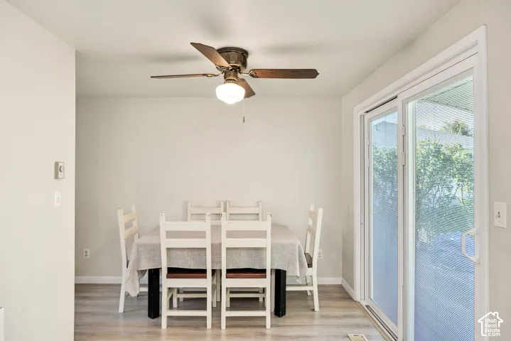 Wood-finish flooring, ceiling fan with integrated lighting, and a sliding glass door