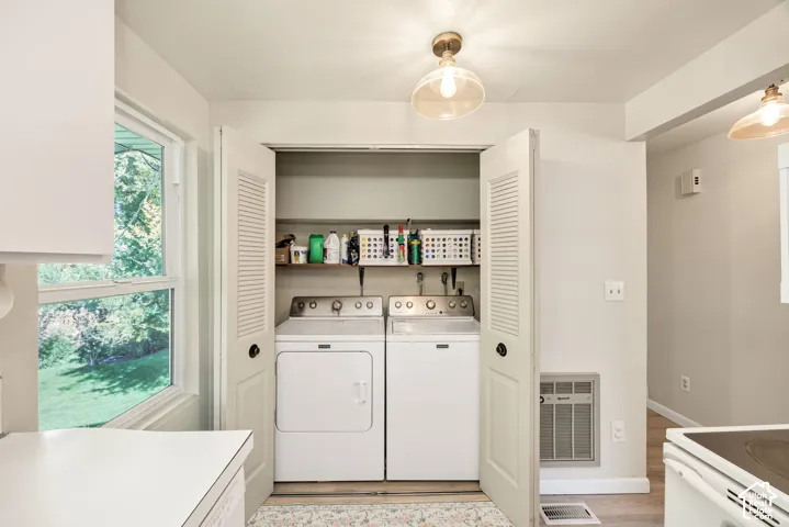 Laundry closet with louvered bi-fold doors, stacked shelving, and overhead lighting