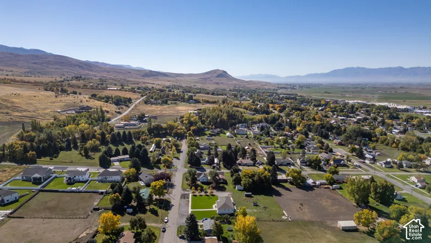 Expansive mountain backdrop with a developed community featuring residential homes and mature trees