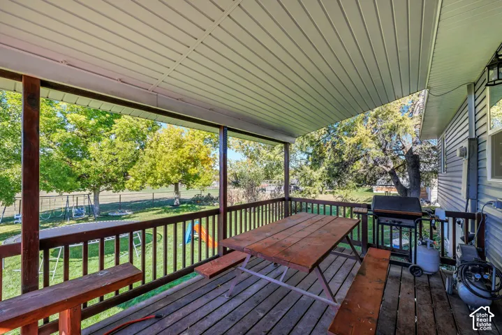 Covered wood deck with slatted wood railings and a finished ceiling