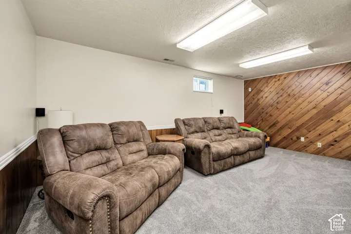 Carpeted room with a wood accent wall, white painted walls, and a small window