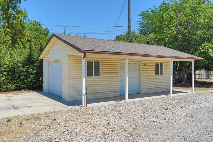 Detached structure featuring horizontal siding, an asphalt shingle roof, and a covered patio area with support columns