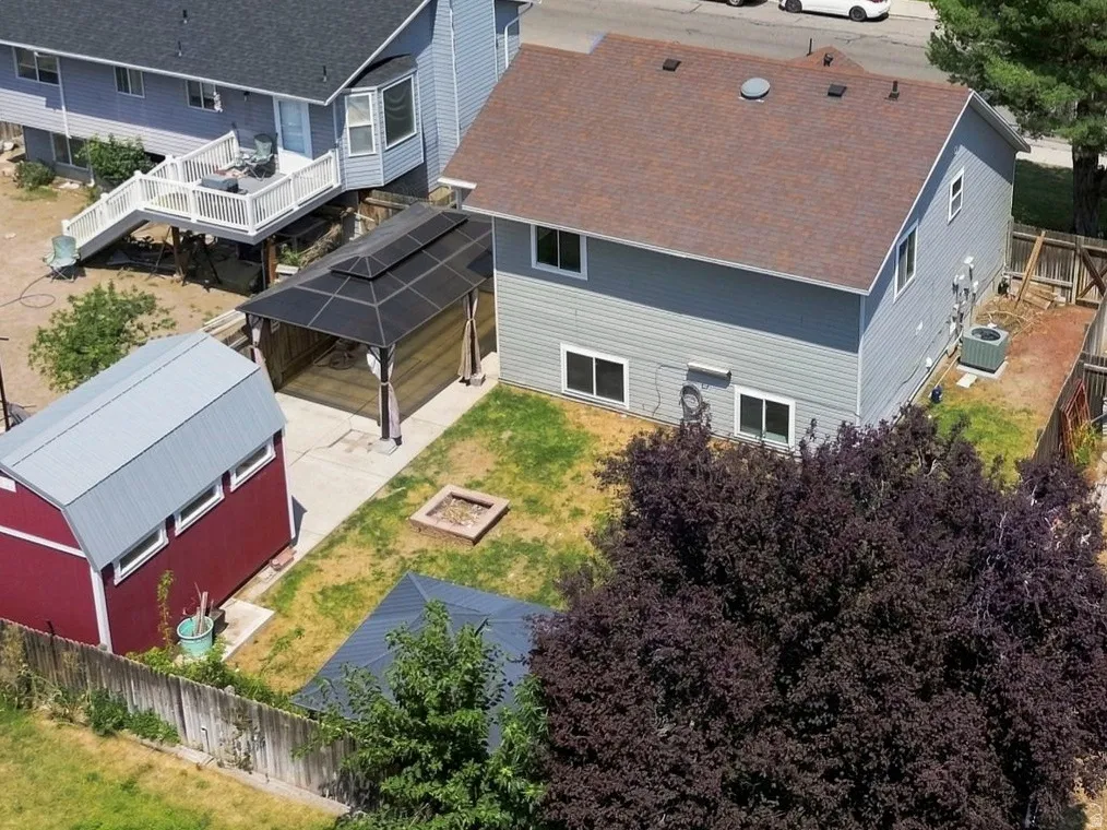 Rear exterior with a multi-level deck, fenced yard, and detached storage shed