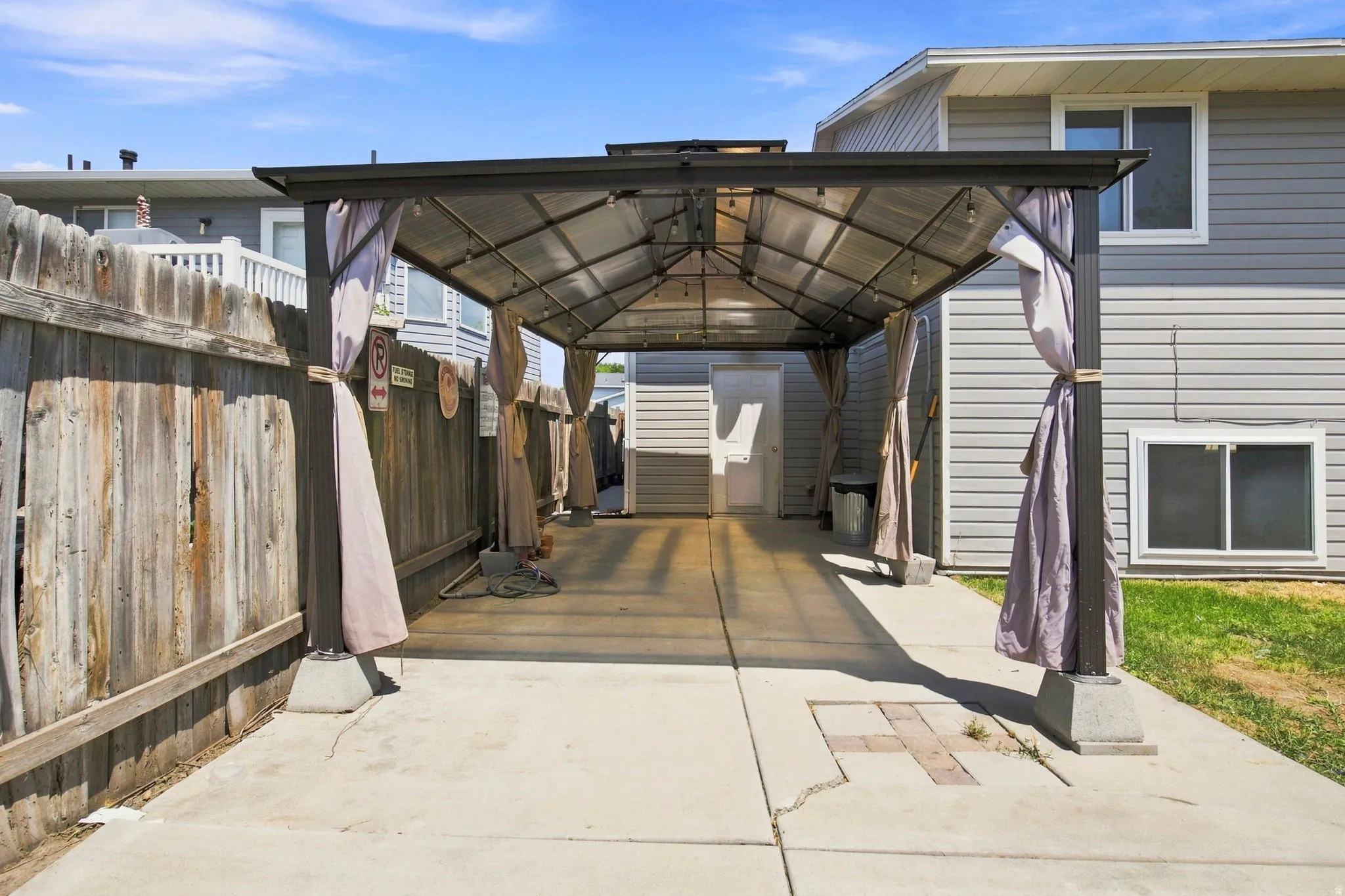 Covered patio structure with a transparent roof and concrete flooring