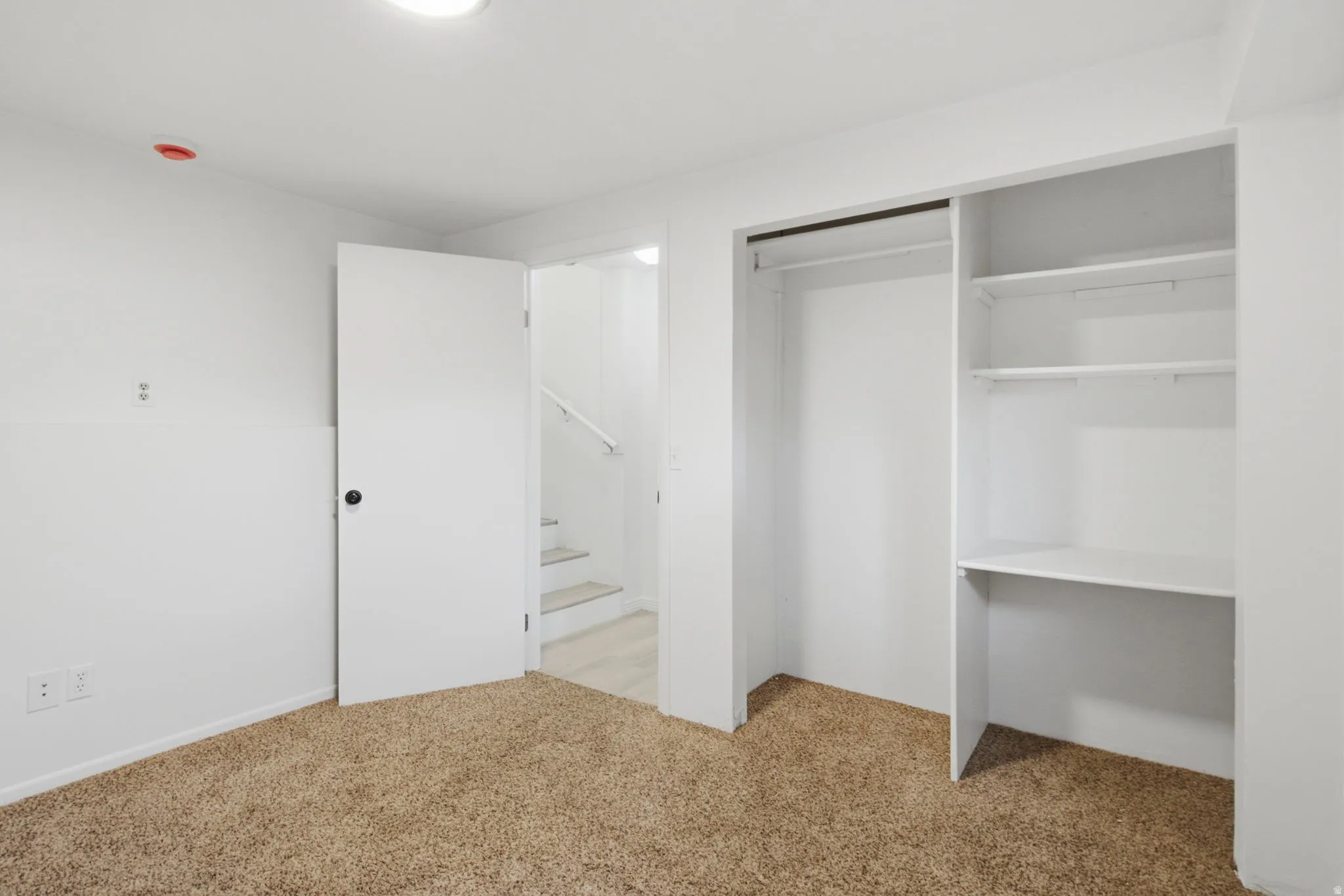 Plush carpet flooring, built-in closet system with shelving, and recessed ceiling lighting