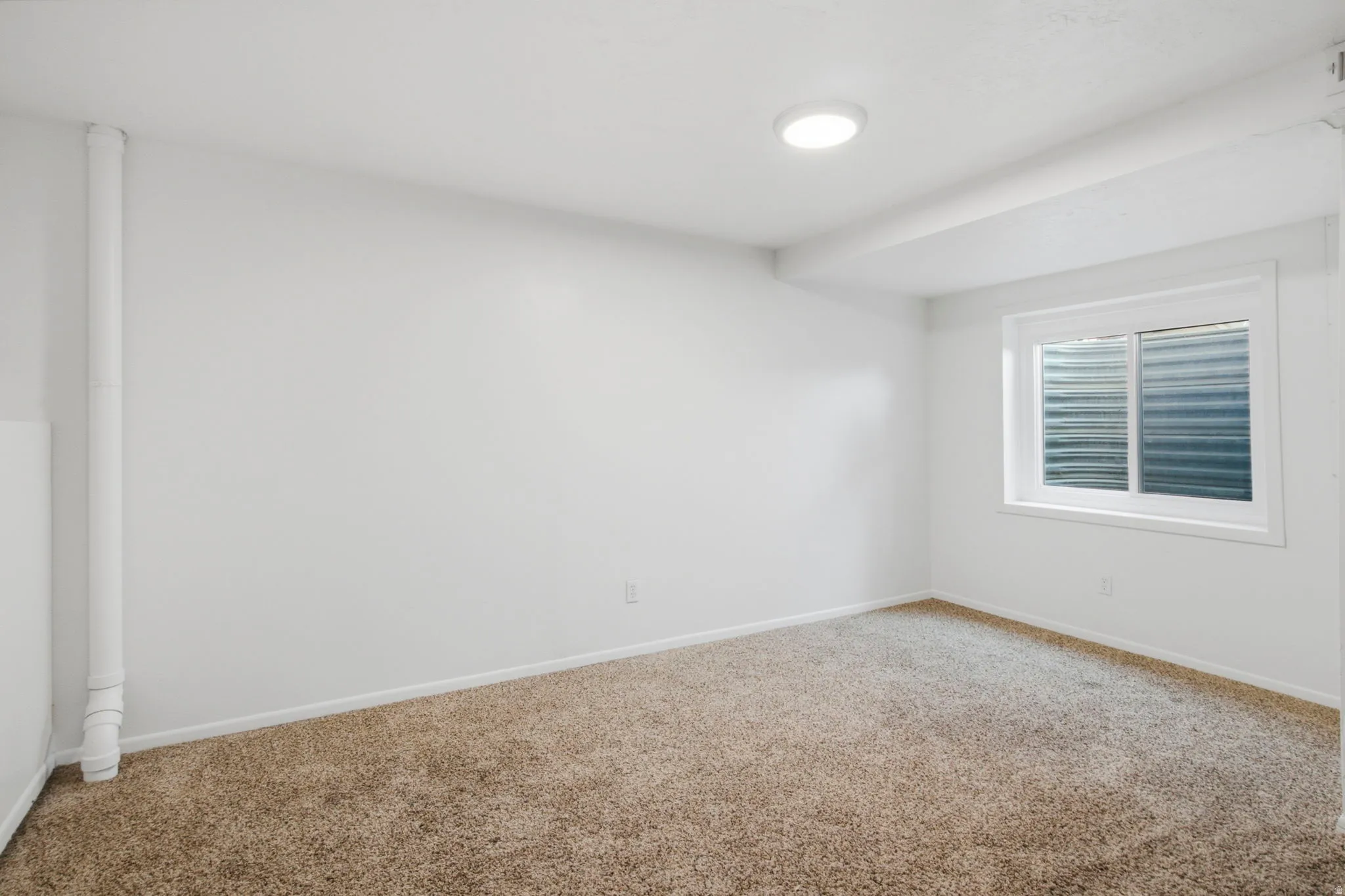 Light-colored wall-to-wall carpeting, white painted walls, recessed ceiling lighting, and a white-framed window