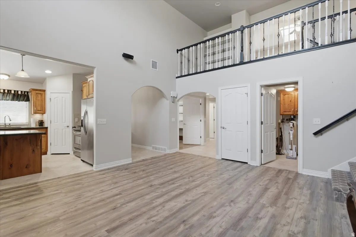 Expansive living area with wood-finish flooring, vaulted ceilings, and an open loft