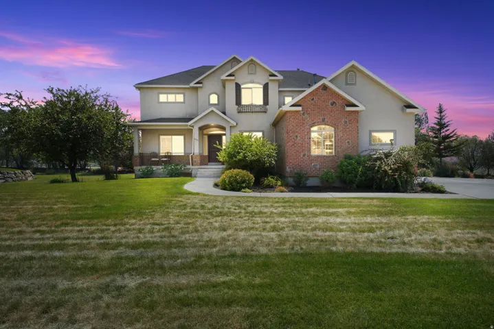 Stucco and brick exterior with a covered porch, arched windows, and a curved paved walkway