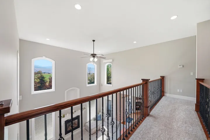 Two-story ceiling with recessed lighting and a ceiling fan