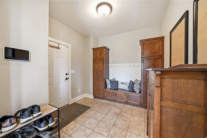 Entryway featuring a built-in bench with storage, beadboard wainscoting, and ceramic tile flooring