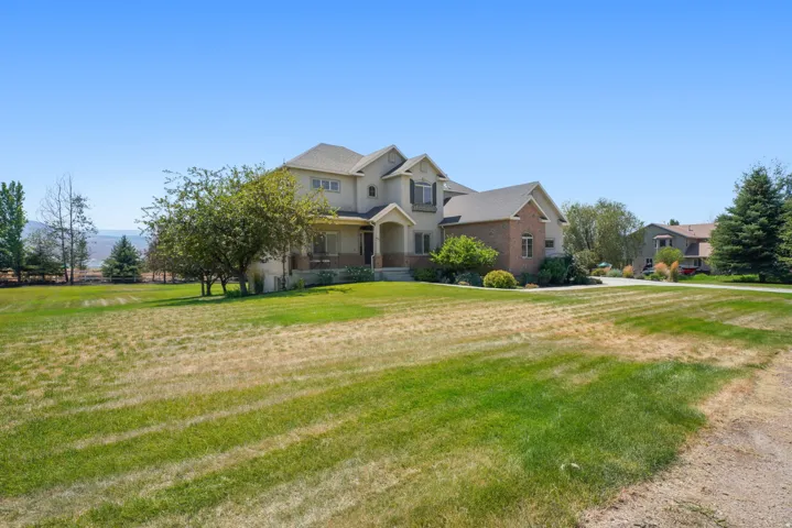 Multi-level residence featuring a brick and stucco exterior, covered front porch, and a dormer window