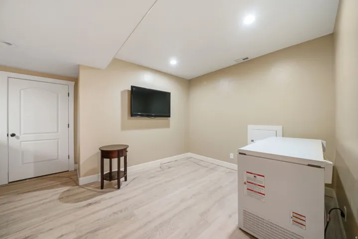Recessed ceiling lighting, wood-finish flooring, and a two-panel interior door