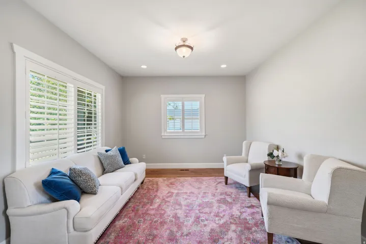 Recessed lighting and a central ceiling fixture illuminate this room with light gray walls