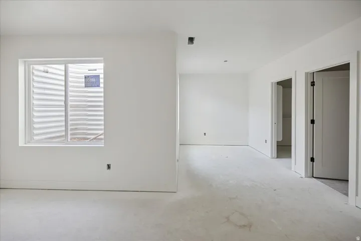 Interior space with white walls, a single window, and two doorways