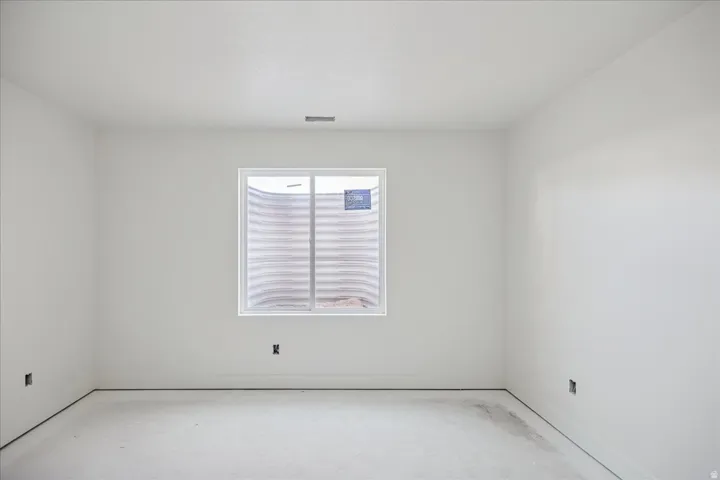 Egress window providing natural light, smooth white walls, and a textured ceiling
