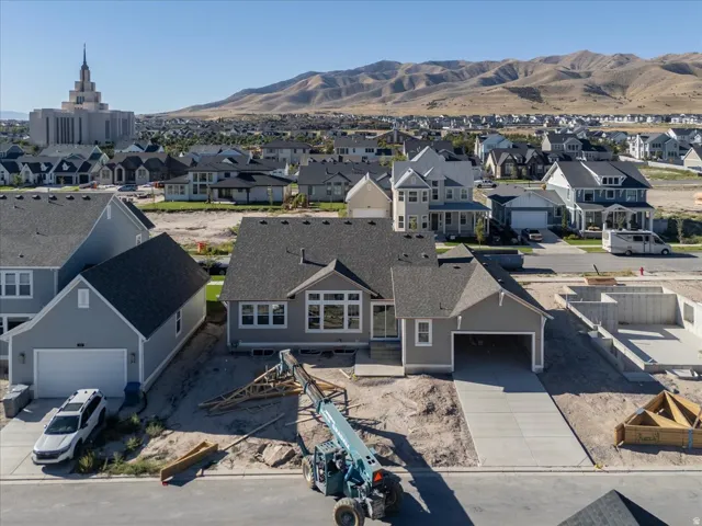 Newly constructed residence featuring a gray exterior, attached garage, and a concrete driveway