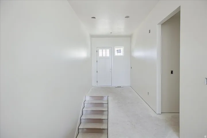 Entryway with a paneled door, sidelight window, and transom window