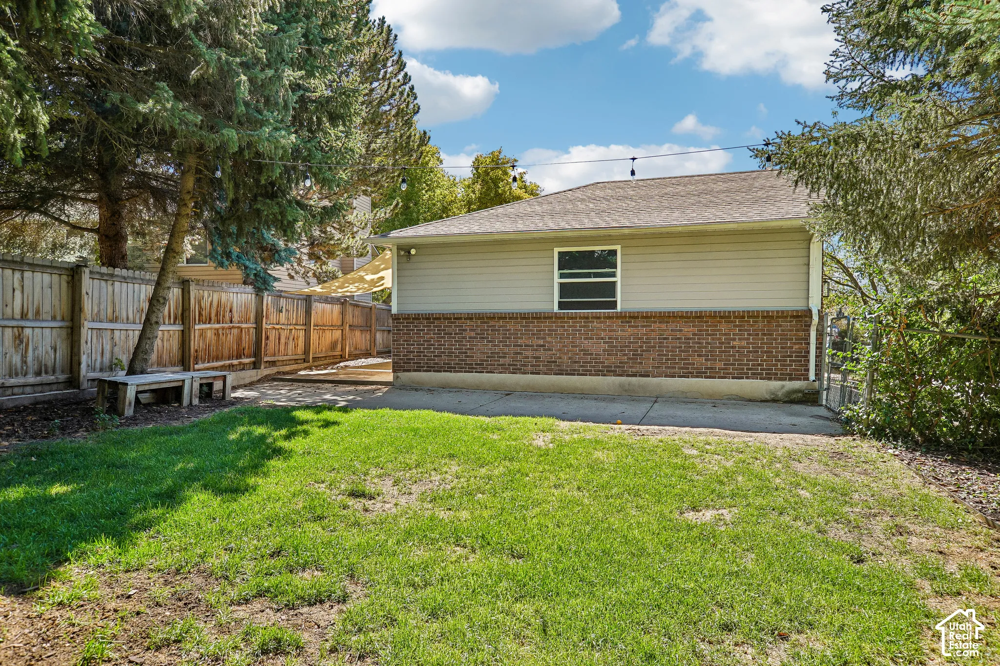 Expansive lawn bordered by a wood privacy fence and mature trees
