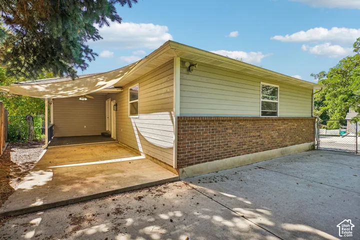 Exterior featuring brick and siding finishes, concrete patio, and a covered porch
