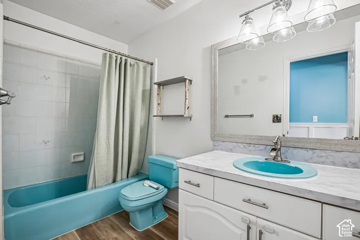 Bathroom featuring a vanity with a light-colored countertop, an undermount sink, and white cabinetry with drawer pulls