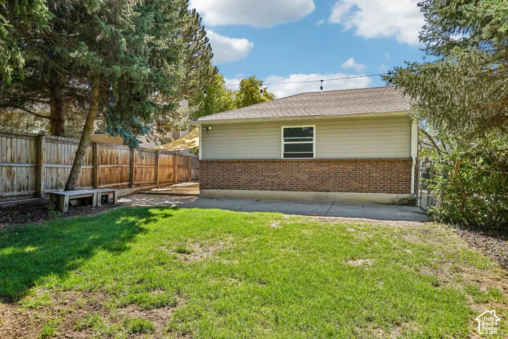 Expansive lawn bordered by a wood privacy fence and mature trees