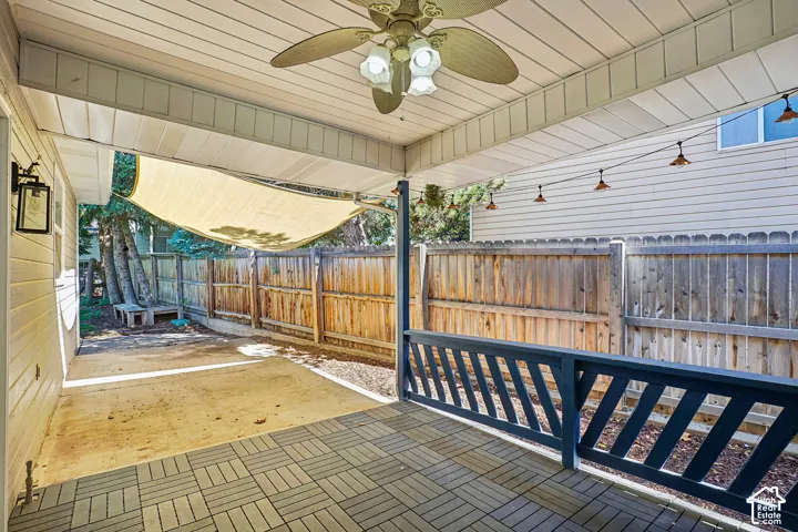 Covered patio with a ceiling fan, outdoor wall lantern, and string lighting