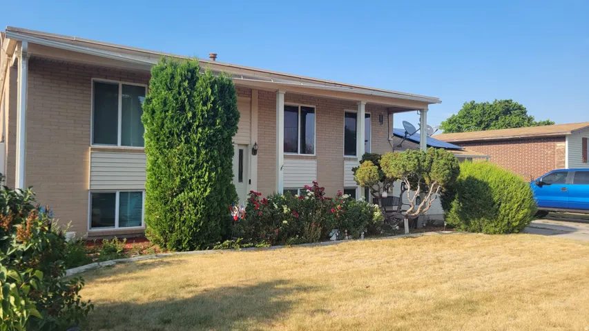 Exterior featuring brick and siding finishes, a covered entry, and established landscaping