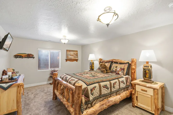 Carpeted flooring, window with blinds, two ceiling-mounted light fixtures, and neutral wall tones