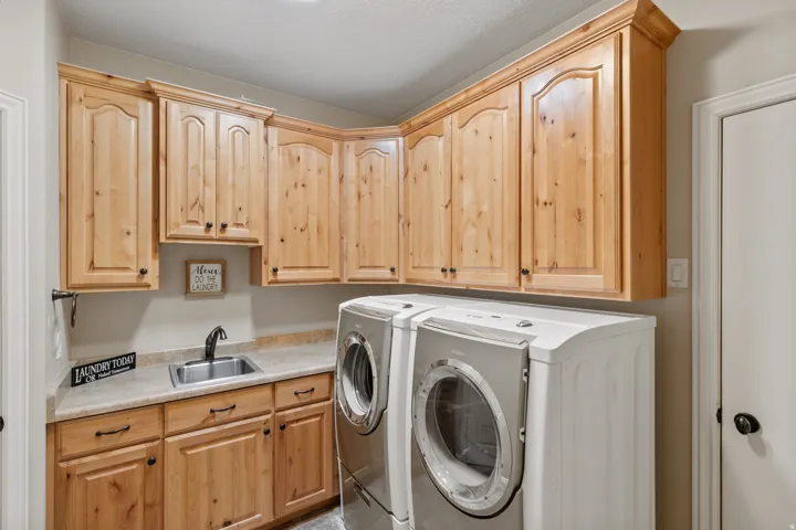 Laundry area featuring wood cabinetry, a utility sink, and a countertop space