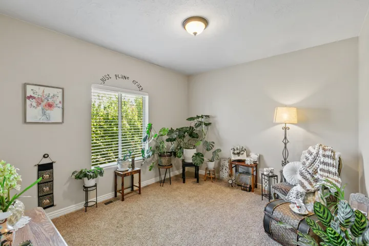 Wall-to-wall carpeting with light-colored walls and a single window with blinds