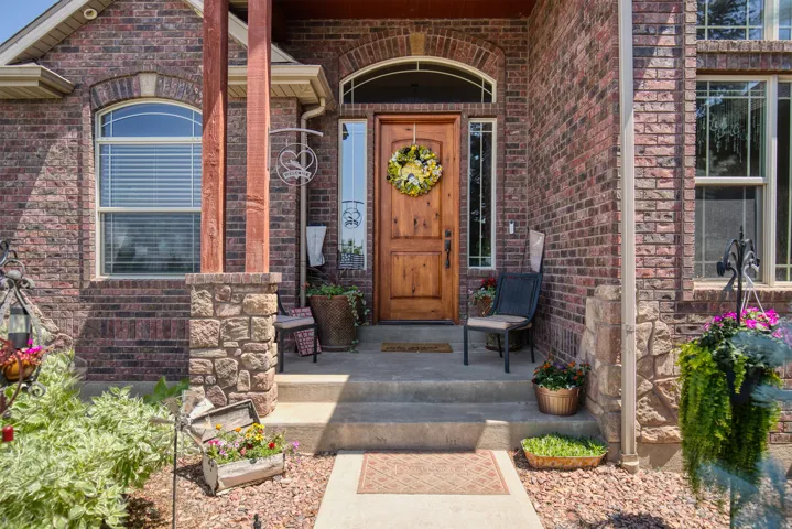Brick exterior with stone accents, arched windows, and a wood-panel front door with sidelights