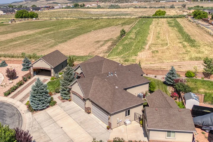 Expansive property featuring a circular driveway, an attached multi-car garage, a detached garage with an extended carport, and a substantial land parcel