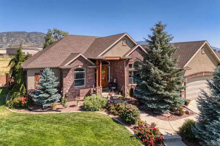 Brick and stucco exterior with multiple gables, arched windows, and a two-car garage