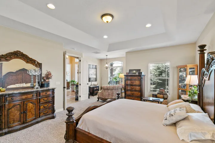 Recessed lighting, tray ceiling, arched doorway, and built-in display cabinetry