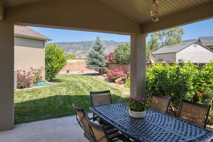 Covered patio with concrete flooring, stucco pillars, and a slatted ceiling