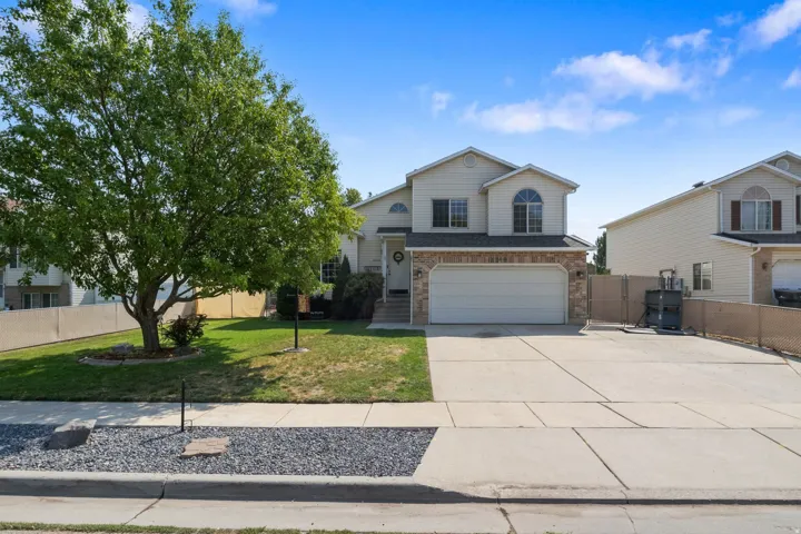 Two-story residence with a stone facade accent, arched window, and attached garage